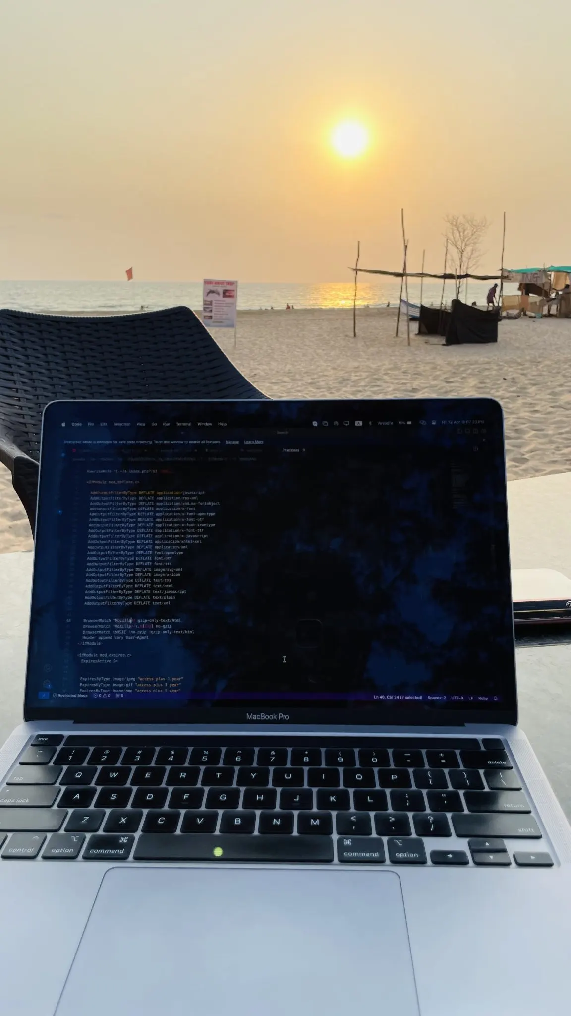 海辺のテーブルでコードを表示したノートパソコン