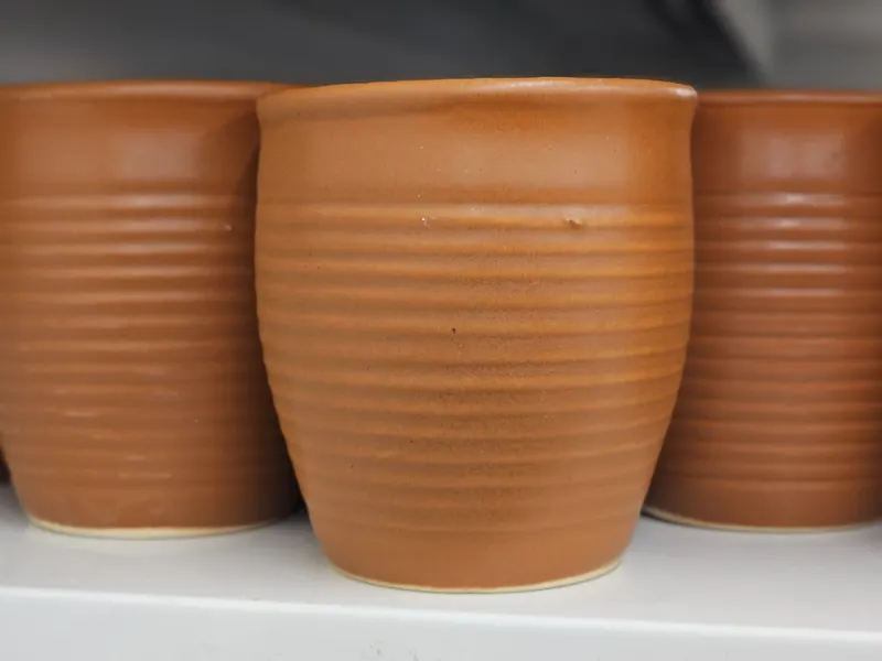 手づくりの陶器のカップが並ぶ棚